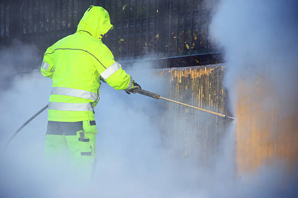 Cleaning man cleaning a wall with high pressure water.